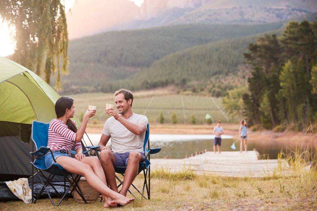 Parents sharing beverage while kids play in the background